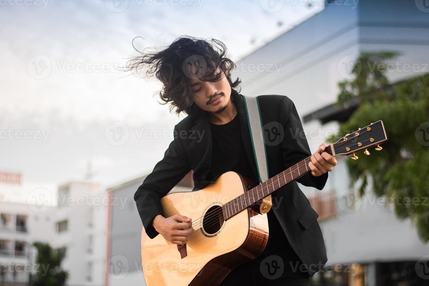 portretten man houdt gitaar spelen muziekfestival buiten, lifestyle mode muziek straat buiten foto