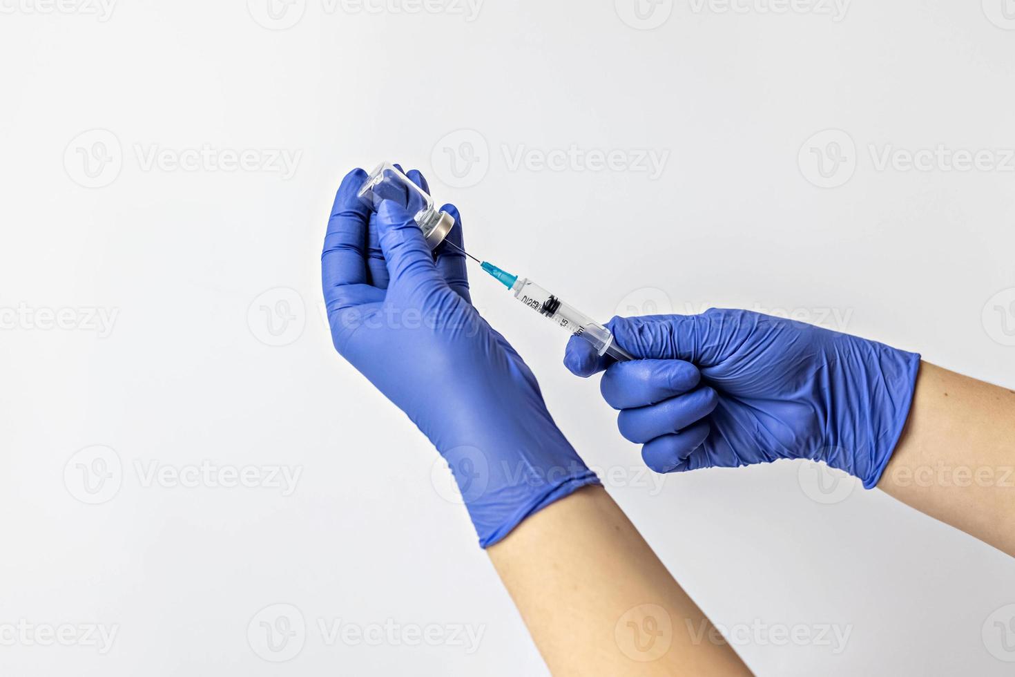 een medisch werker in medische handschoenen trekt een dosis coronavirusvaccin in een spuit. het concept van vaccinatie, immunisatie, preventie van mensen van covid-19 foto