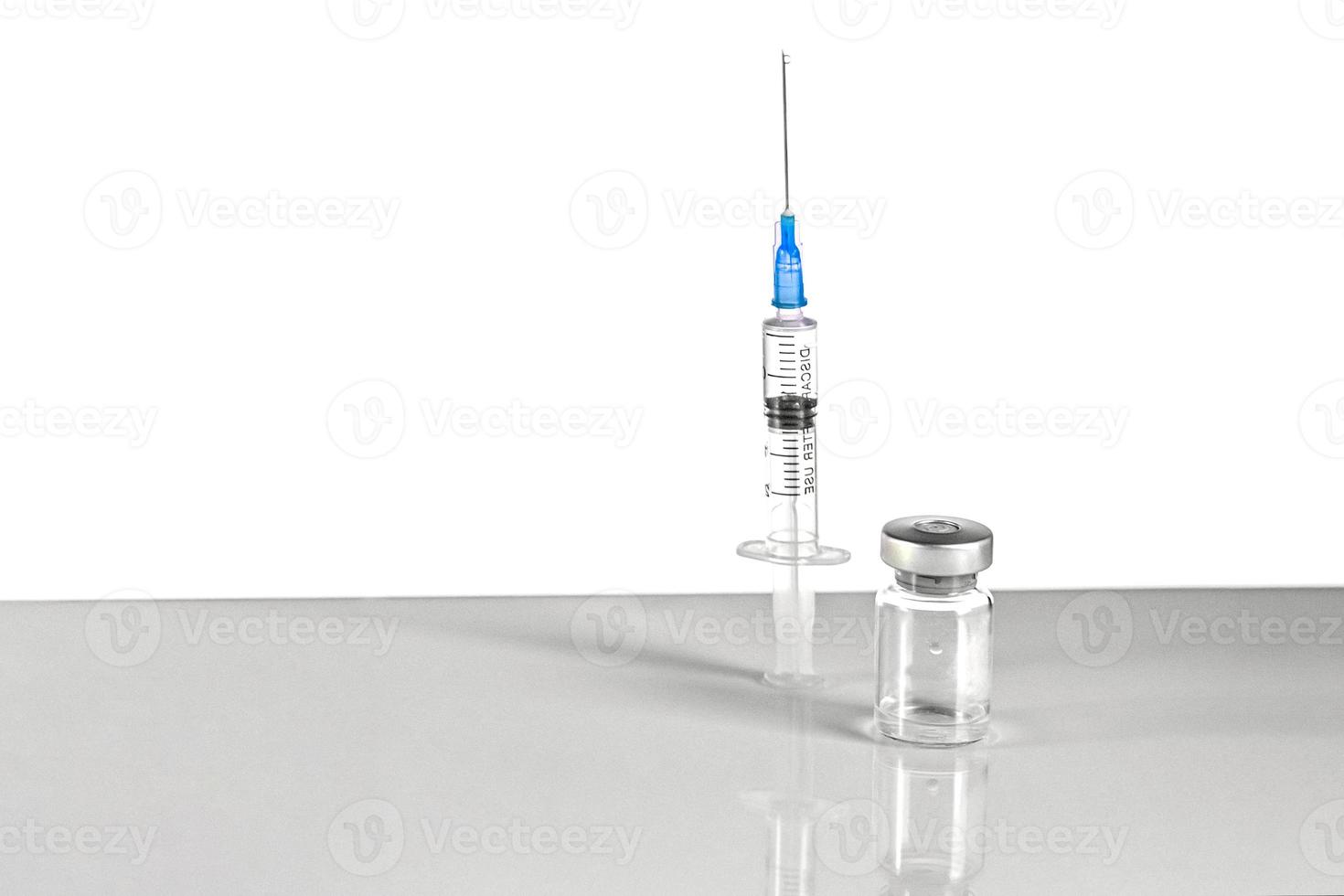 spuit en injectieflacon met coronavirusvaccin, injectieflacondosis op een grijze achtergrond. preventie, medisch concept, covid-19 immunisatie. foto