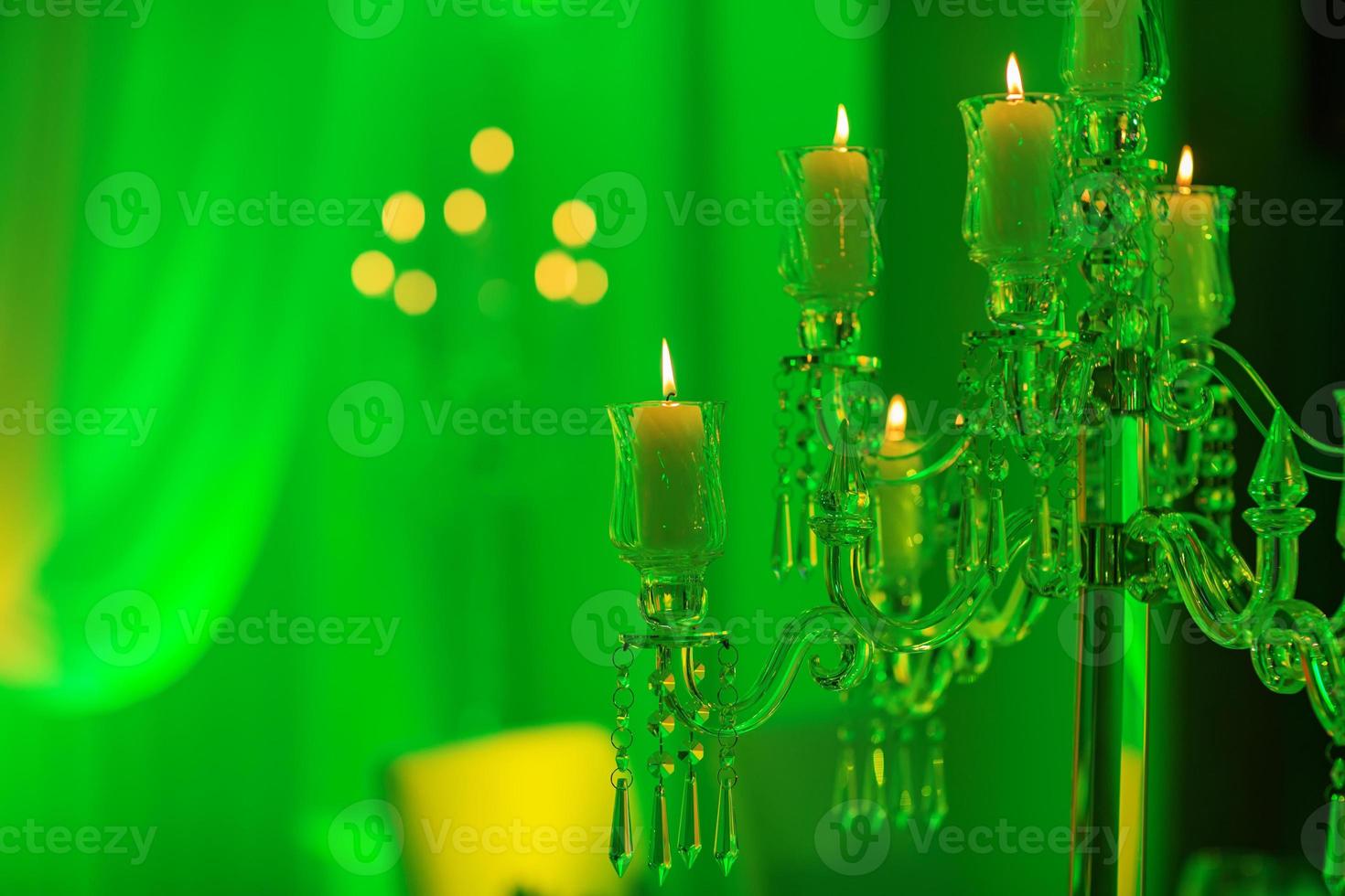 bruiloft decoratie. kristallen kandelaar met kaarsen in groen licht foto