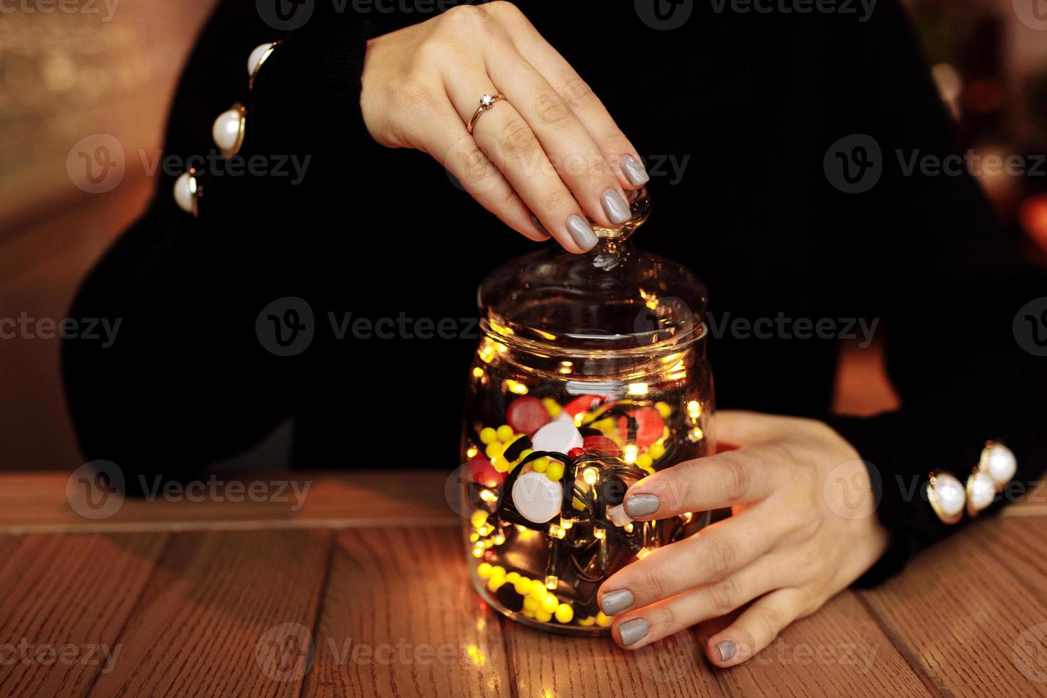 jonge vrouw die fles geneeskunde toont. gekleurde capsules. verschillende medicinale capsule morst uit een glas. geneeskunde concept foto