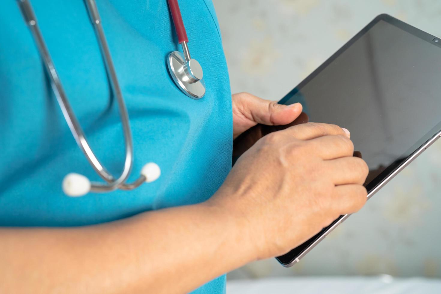 arts die digitale tablet vasthoudt om gegevens te zoeken voor behandelpatiënt in verpleegafdeling, gezond sterk medisch concept. foto