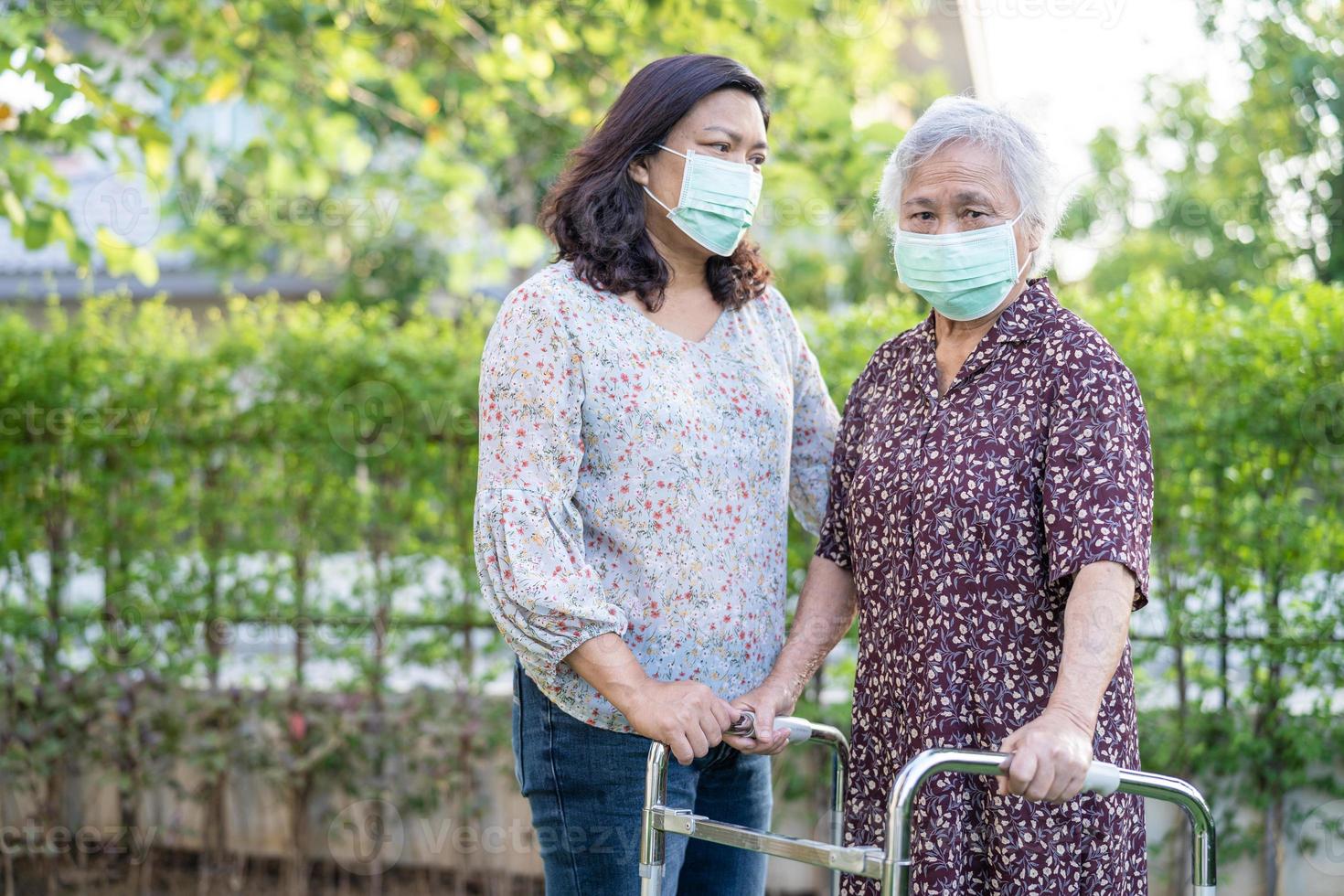 aziatische senior of oudere oude dame vrouw loopt met rollator en draagt een gezichtsmasker ter bescherming van de veiligheidsinfectie covid-19 coronavirus. foto