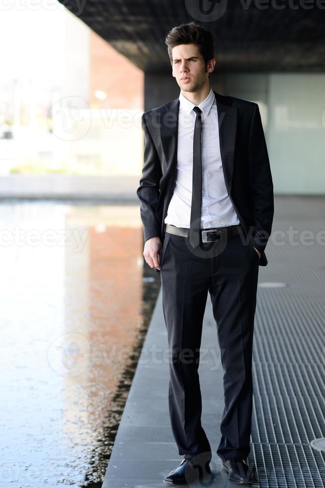 aantrekkelijke jonge zakenman in stedelijke achtergrond foto
