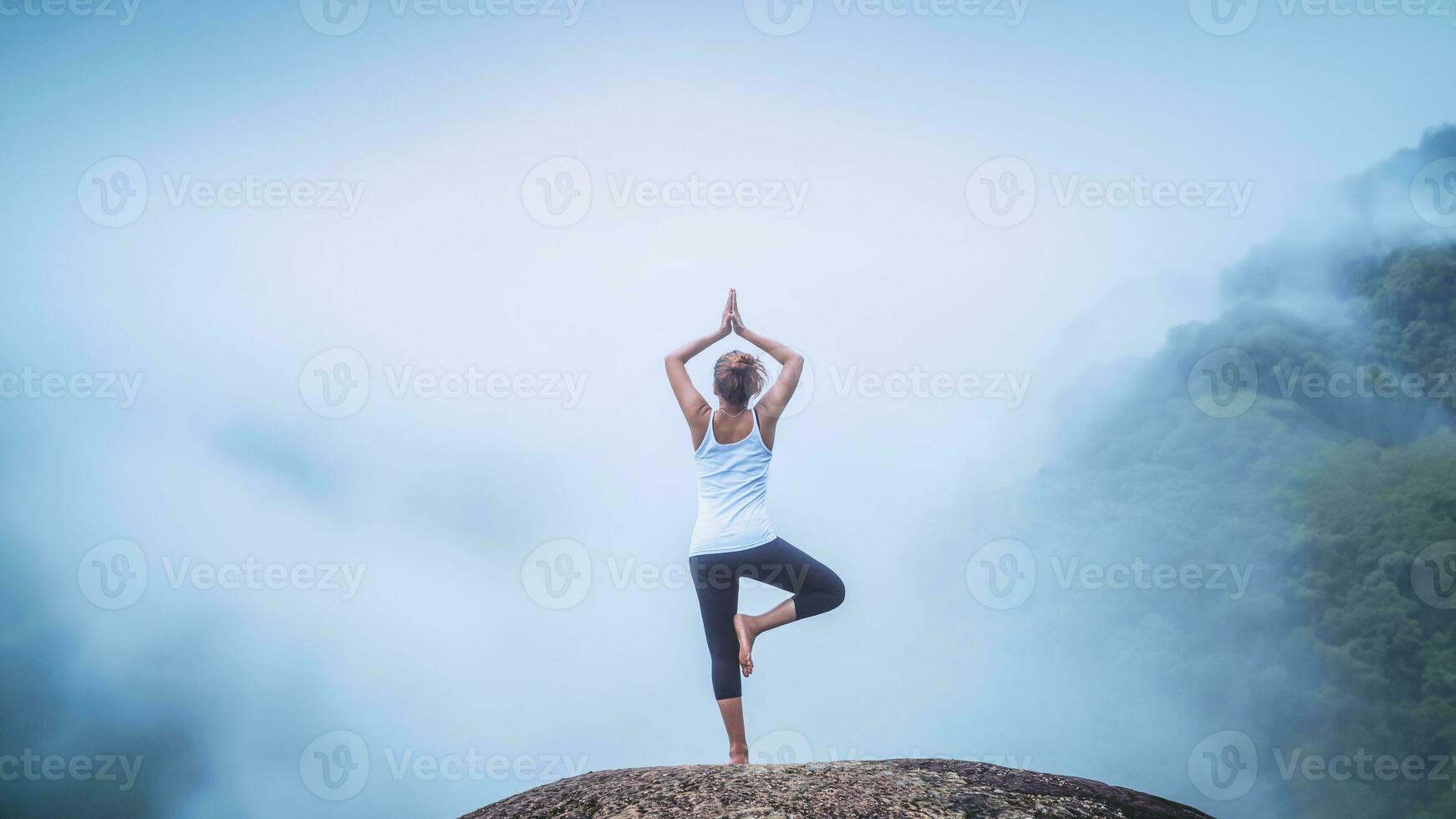 Aziatisch vrouw kom tot rust in de vakantie. Speel als yoga. Aan de moutain rots klif foto