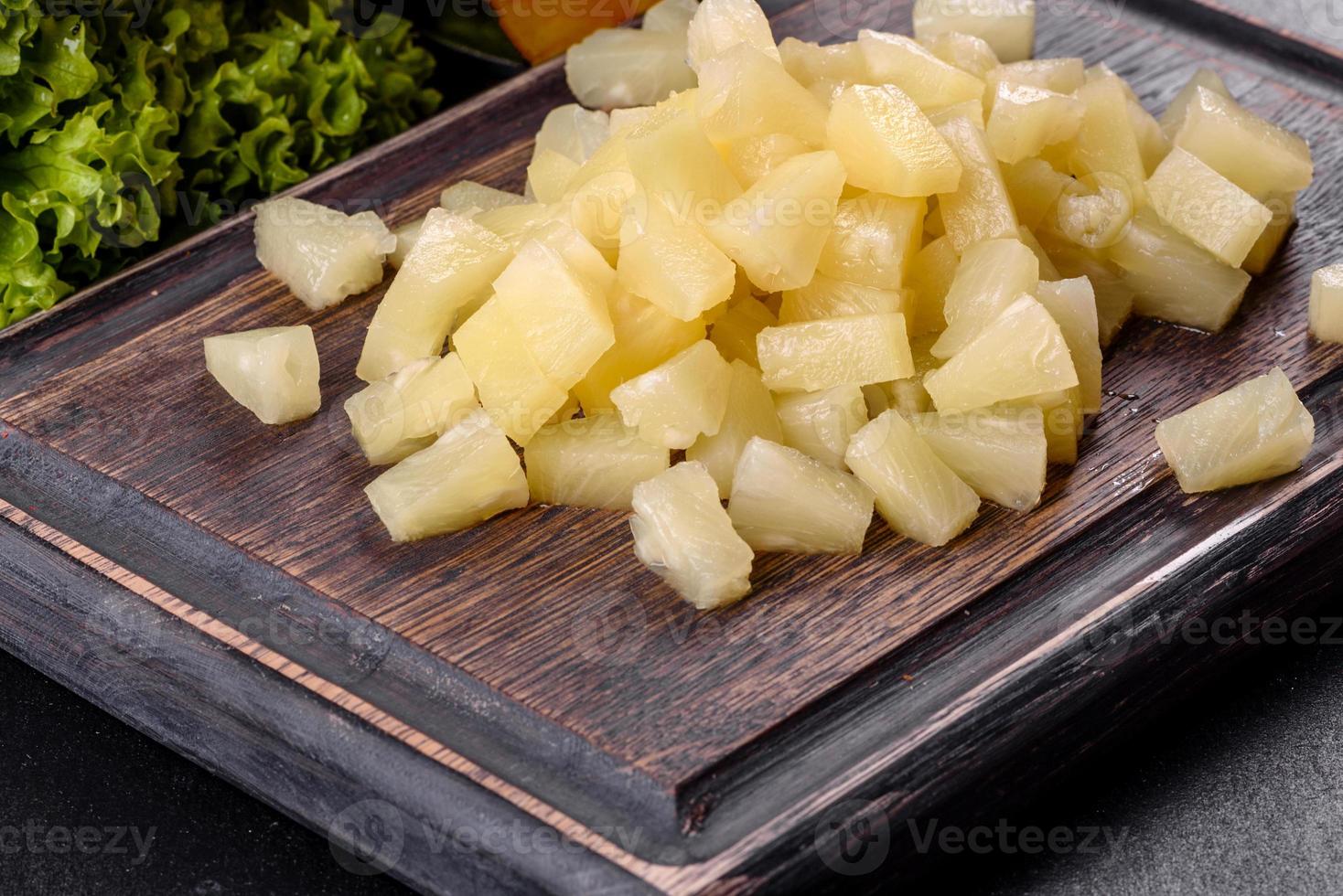 ananas ingeblikt met stukjes op een houten snijplank foto