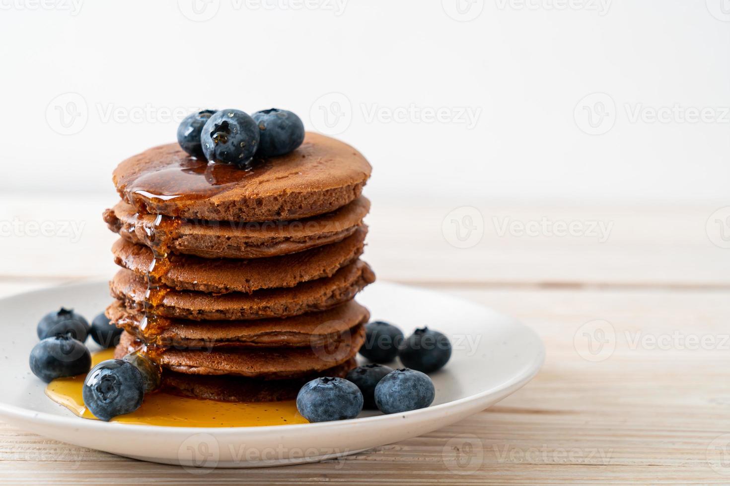 chocolade pannenkoek stapel met bosbessen en honing op een bord foto