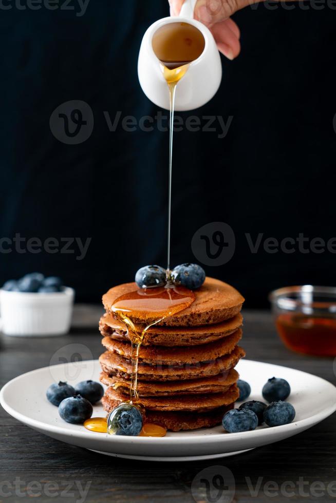 chocolade pannenkoek stapel met bosbessen en honing op een bord foto