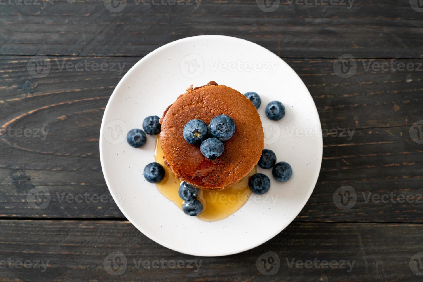 chocolade pannenkoek stapel met bosbessen en honing op een bord foto