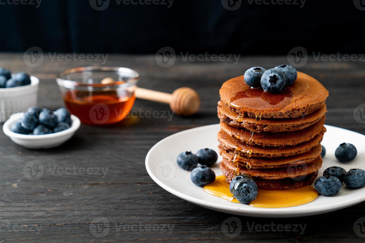 chocolade pannenkoek stapel met bosbessen en honing op een bord foto