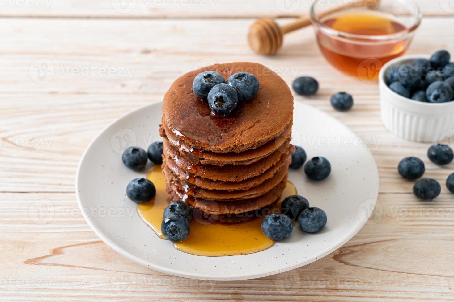 chocolade pannenkoek stapel met bosbessen en honing op een bord foto