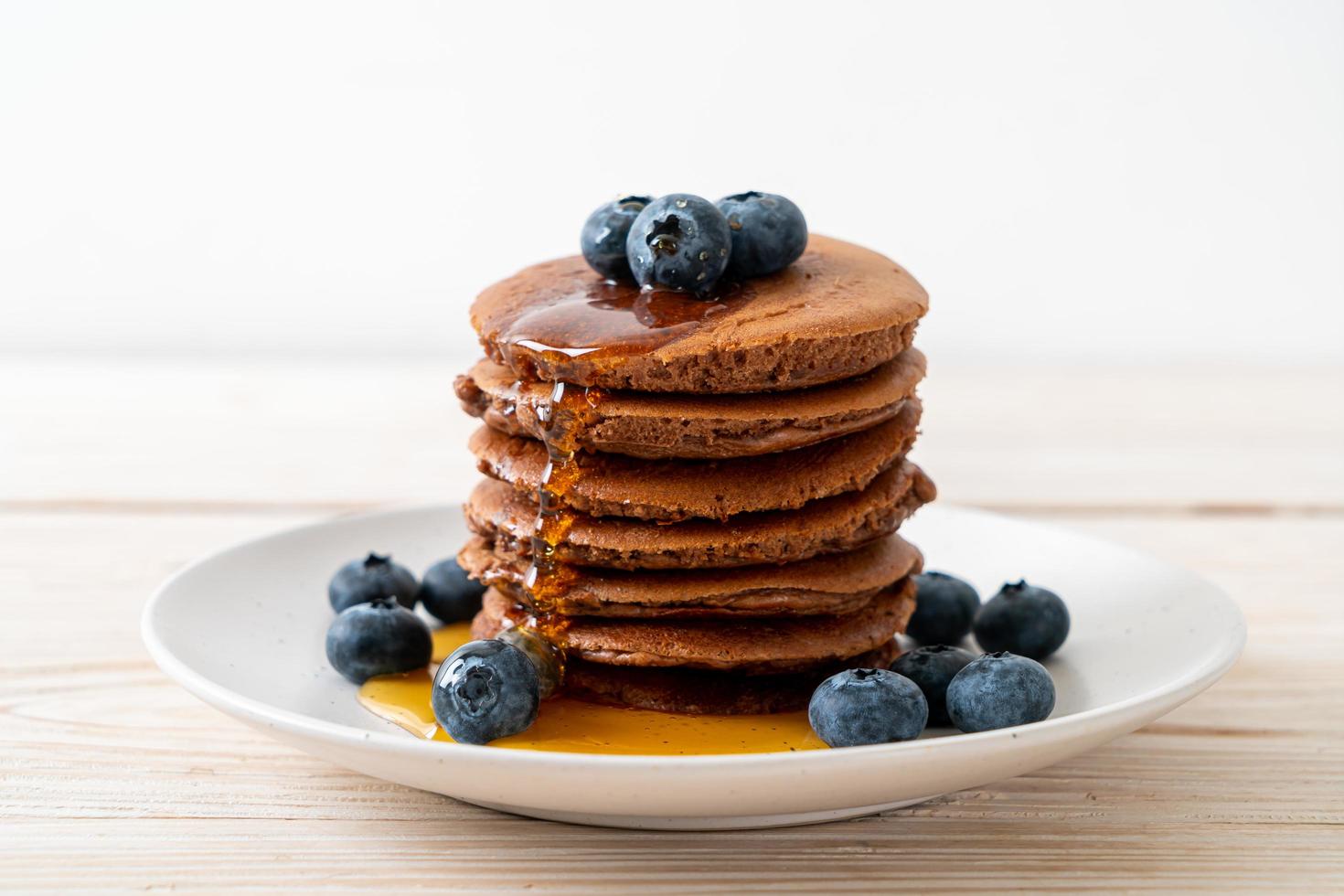 chocolade pannenkoek stapel met bosbessen en honing op een bord foto