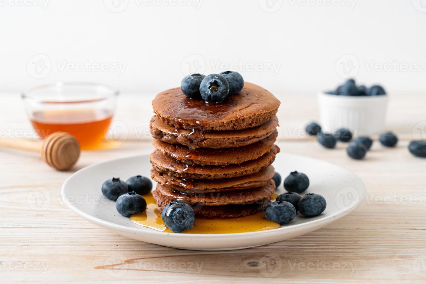 chocolade pannenkoek stapel met bosbessen en honing op een bord foto