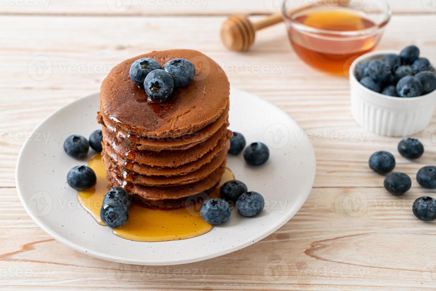 chocolade pannenkoek stapel met bosbessen en honing op een bord foto