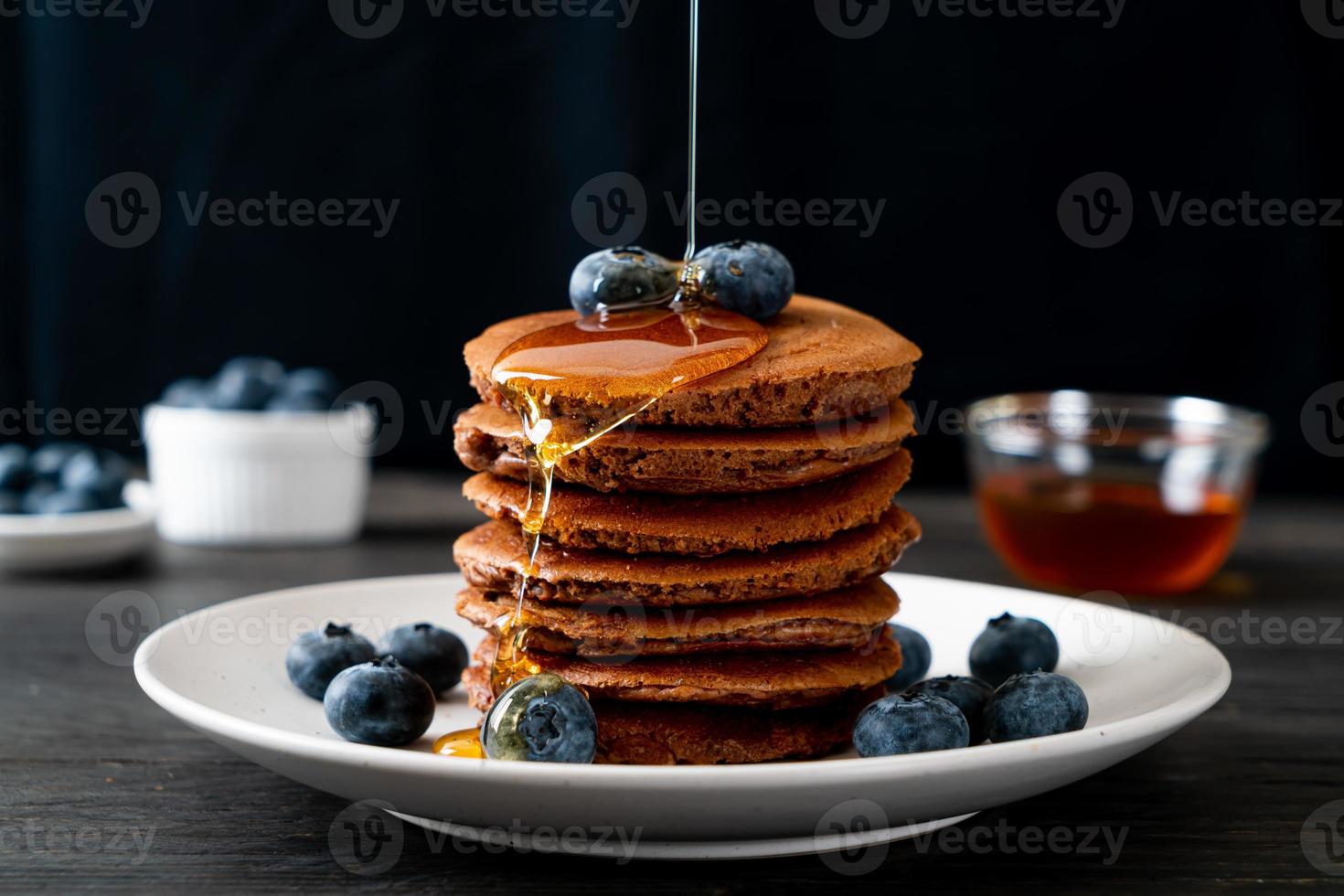 chocolade pannenkoek stapel met bosbessen en honing op een bord foto