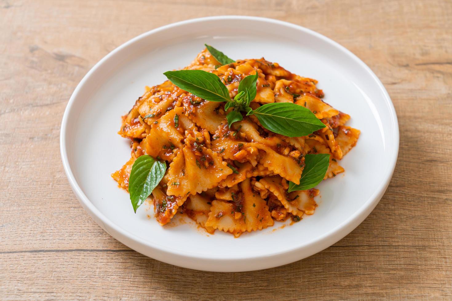 farfalle pasta met basilicum en knoflook in tomatensaus - italiaanse saus foto