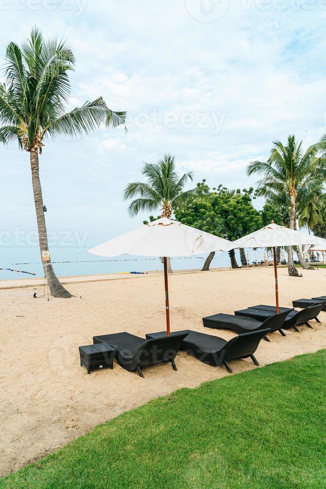 lege strandstoel met palmbomen op het strand met zee achtergrond foto