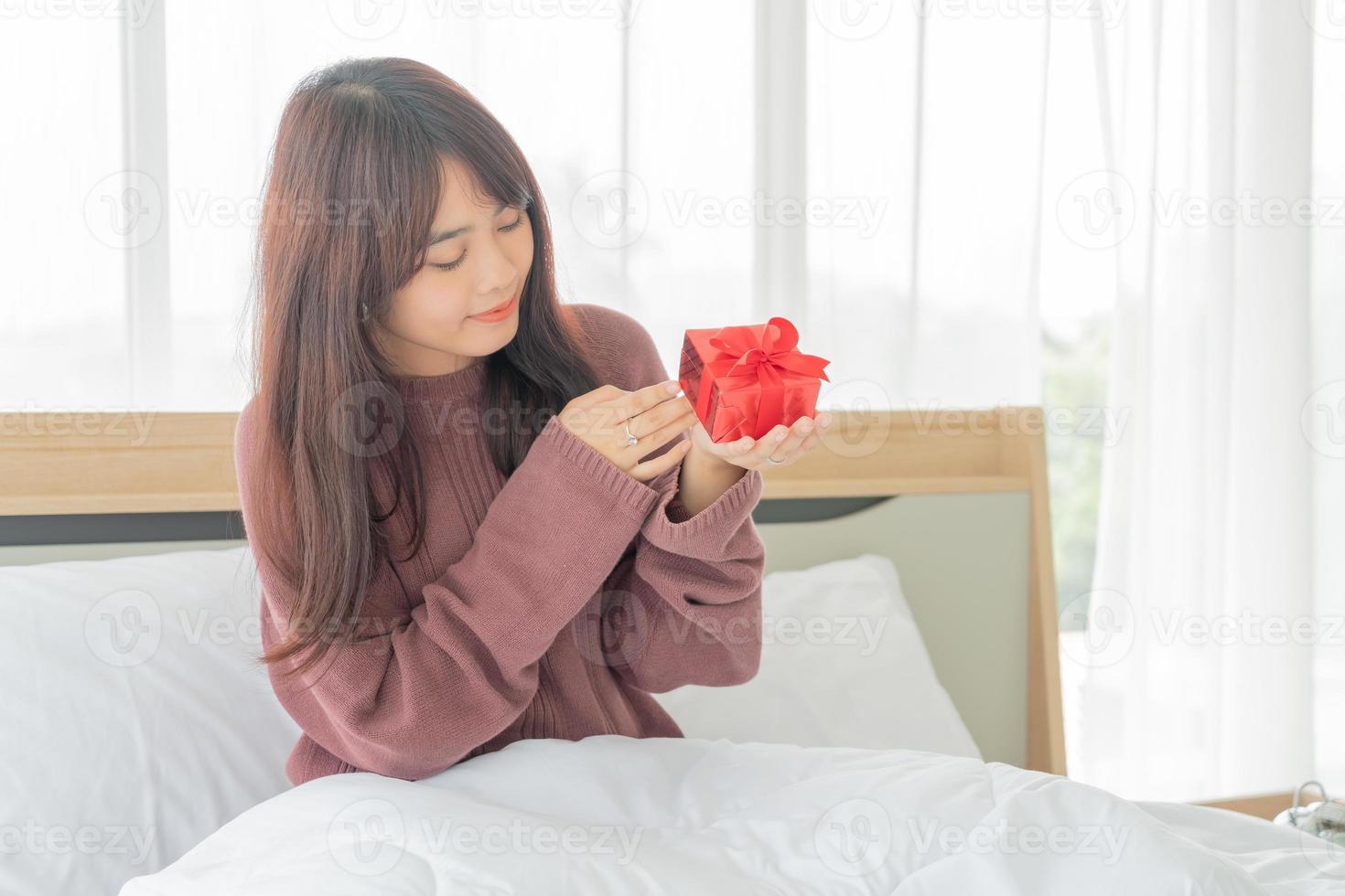 Aziatische vrouw ontvangt graag een geschenkdoos of cadeau foto