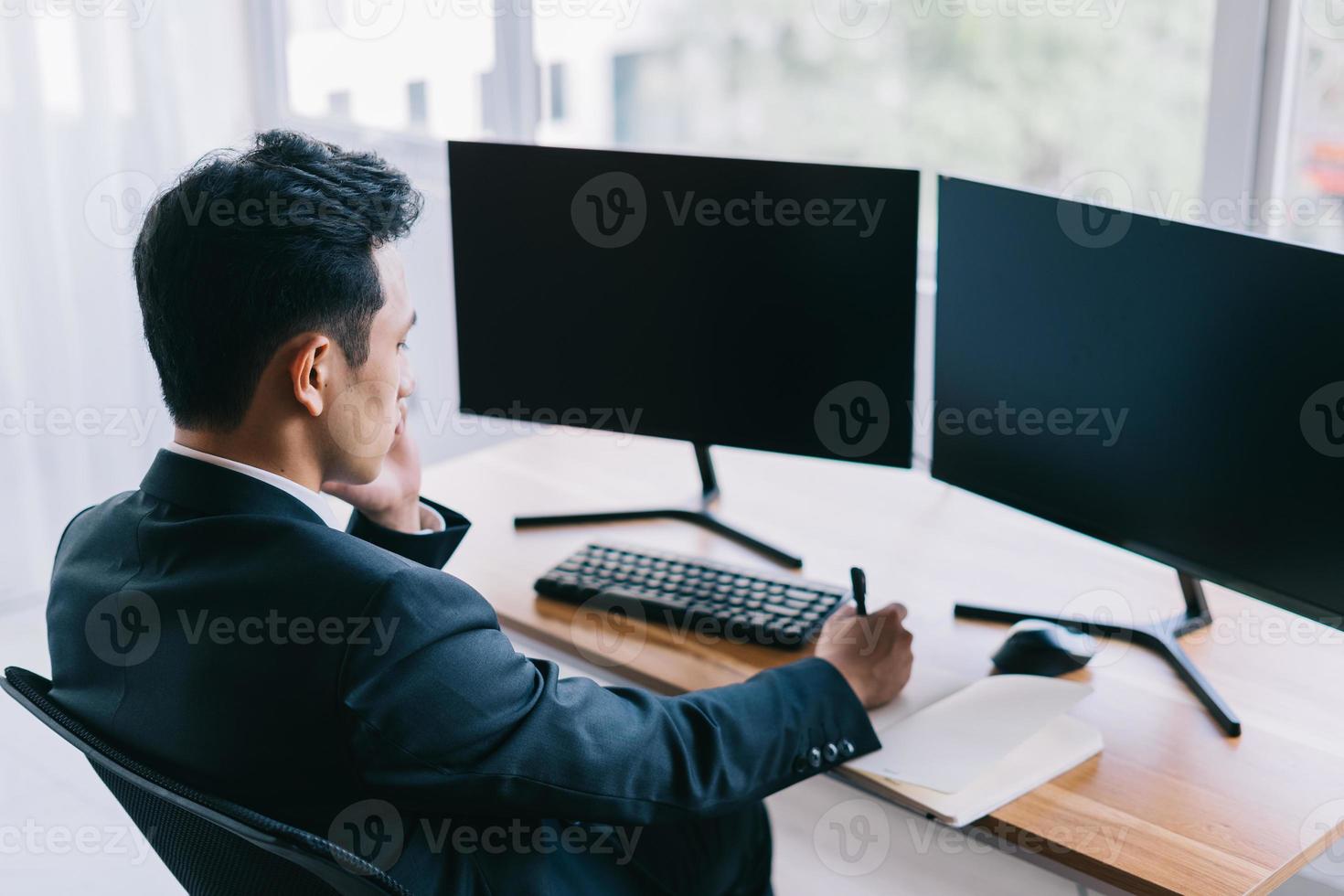 Aziatische zakenman gericht op werken aan de telefoon foto