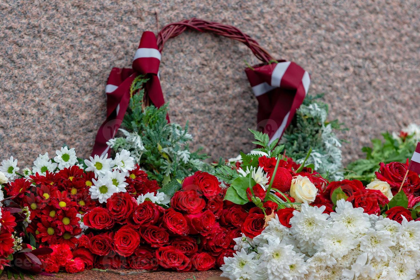 Letland 100 jaar. composities van rode en witte bloemen bij het vrijheidsmonument in de stad Riga, Letland foto