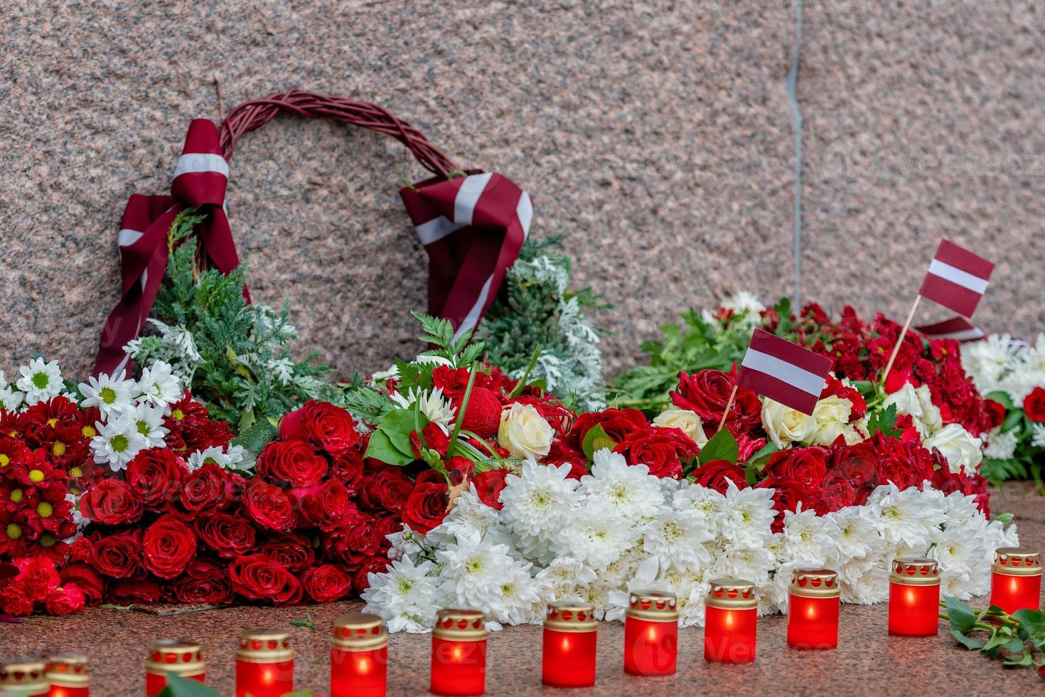 Letland 100 jaar. composities van rode en witte bloemen bij het vrijheidsmonument in de stad Riga, Letland foto