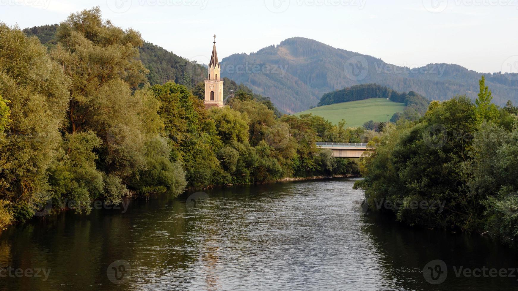 uitzicht op de rivier de mur met kerk in leoben, oostenrijk foto