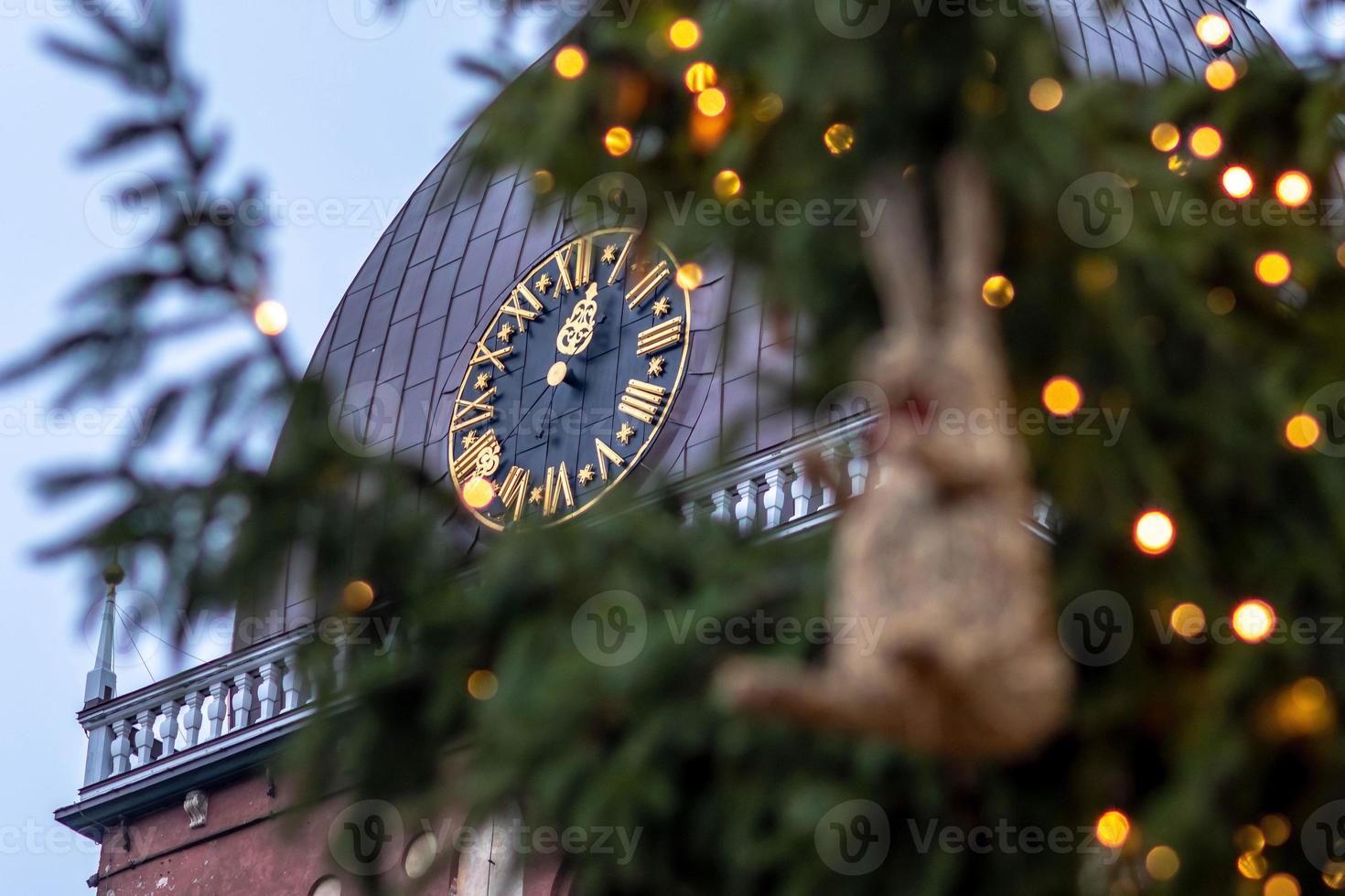 klok in kerktoren. op de voorgrond kerstversiering en verlichting. foto