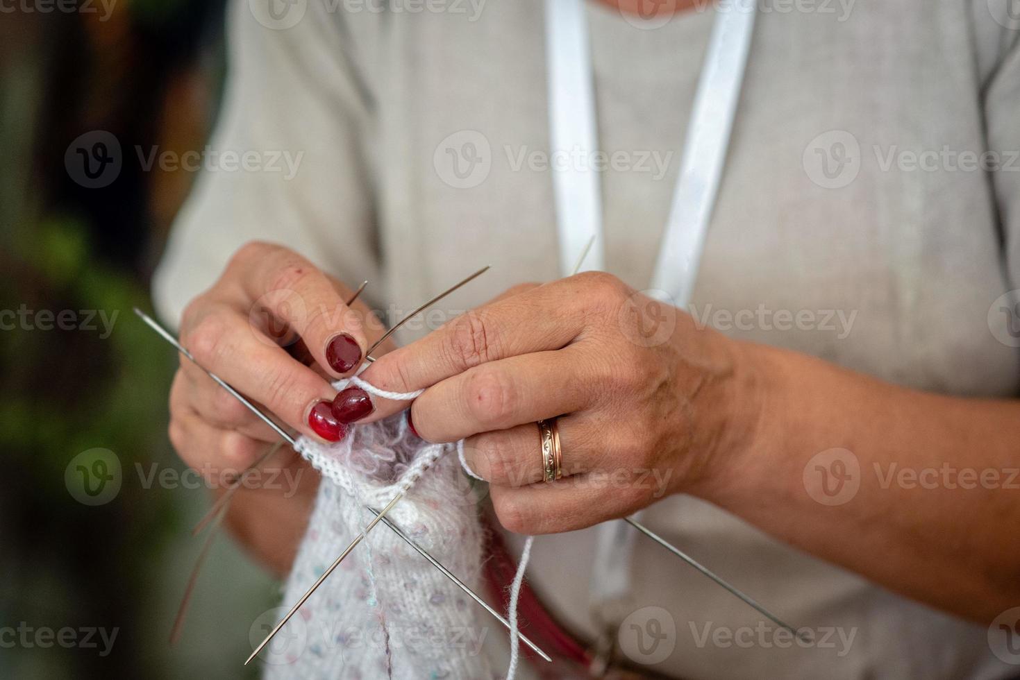 close-up van de handen van een oudere vrouw die aan het breien is. - afbeelding foto