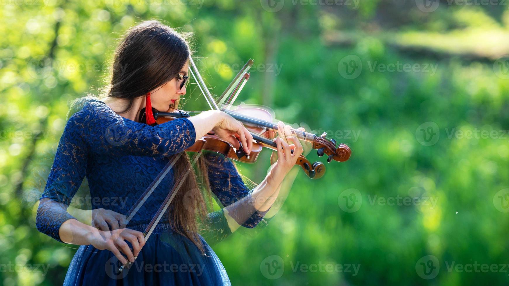 creatieve compositie. jonge vrouw die viool speelt in het park. ondiepe scherptediepte - afbeelding foto