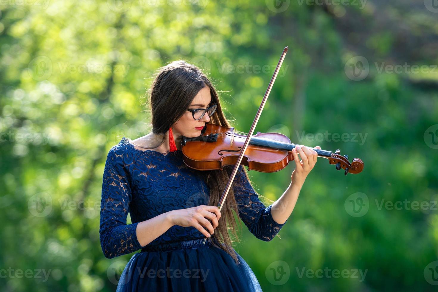 jonge vrouw die viool speelt in het park. ondiepe scherptediepte - afbeelding foto