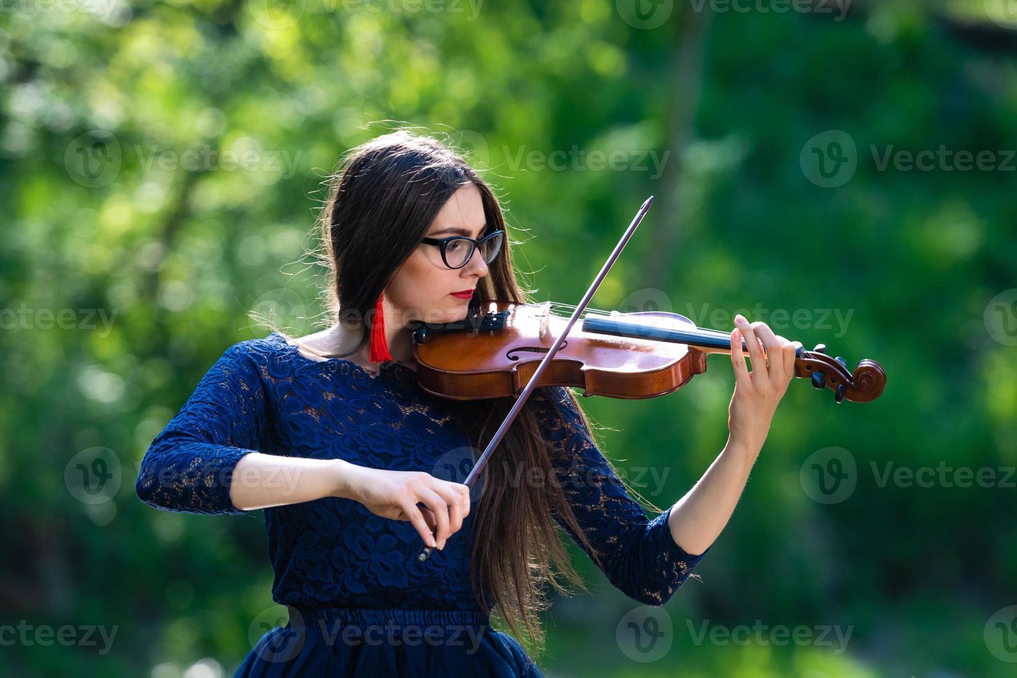 jonge vrouw die viool speelt in het park. ondiepe scherptediepte - afbeelding foto