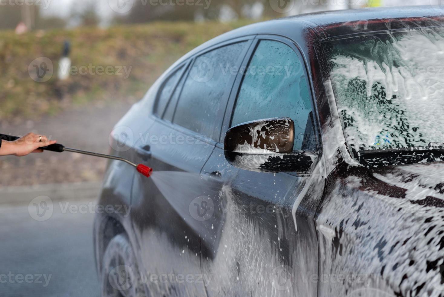 auto zonder aanraking wassen self-service. wassen met water en schuim. foto