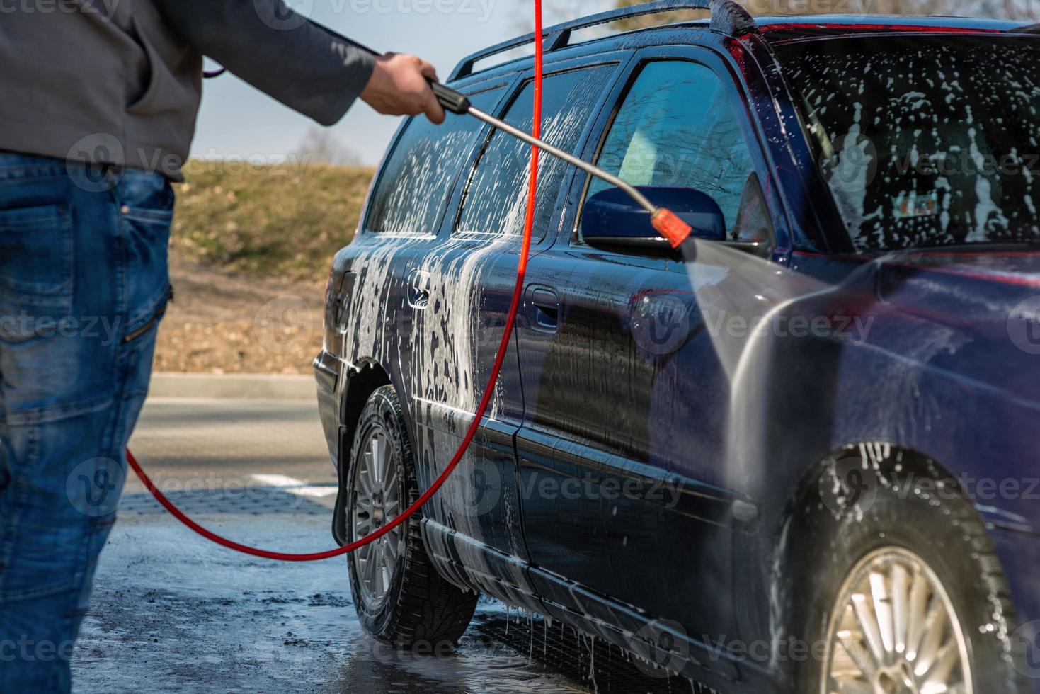 auto zonder aanraking wassen self-service. wassen met water en schuim. foto