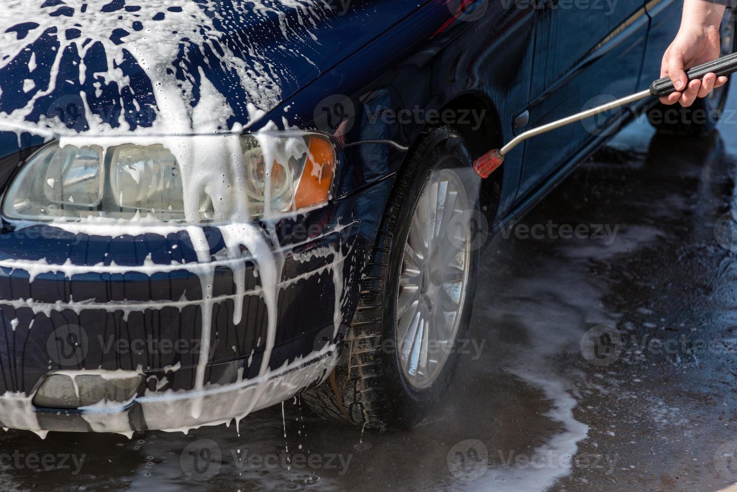 auto zonder aanraking wassen self-service. wassen met water en schuim. foto