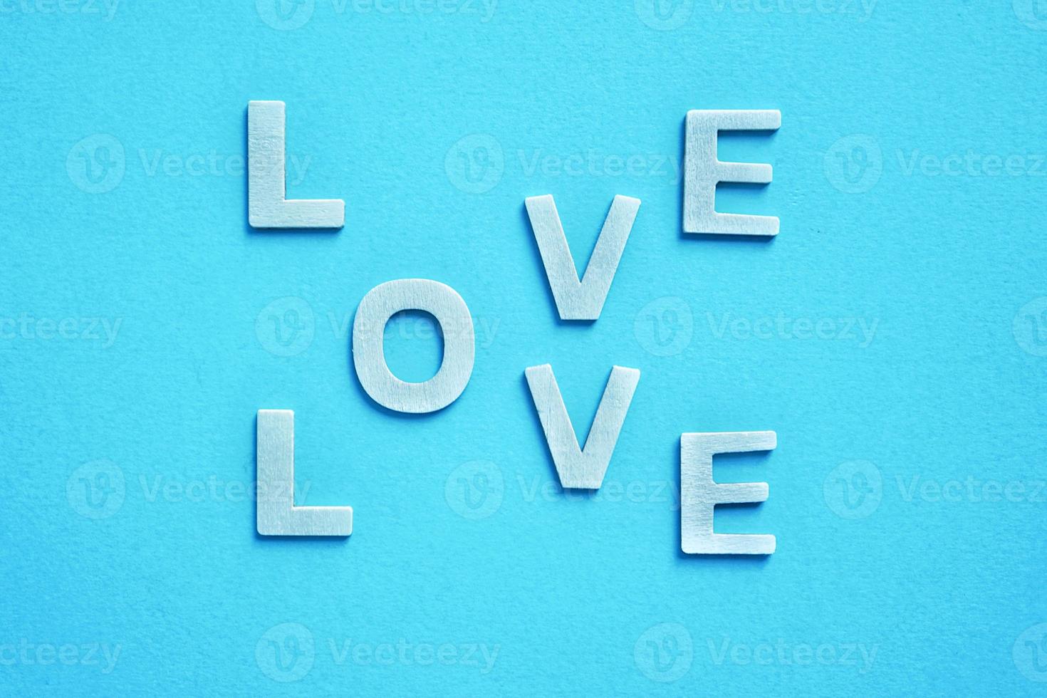 liefdeswoord met houten letters op de blauwe achtergrond voor Valentijnsdag foto