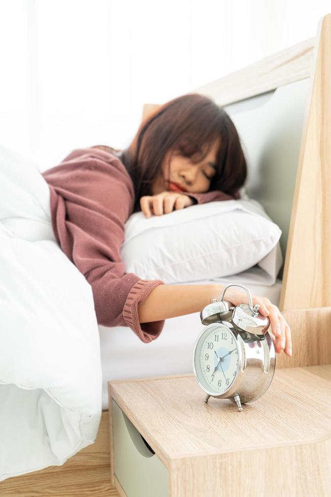 Aziatische vrouw op bed en 's ochtends wakker worden foto