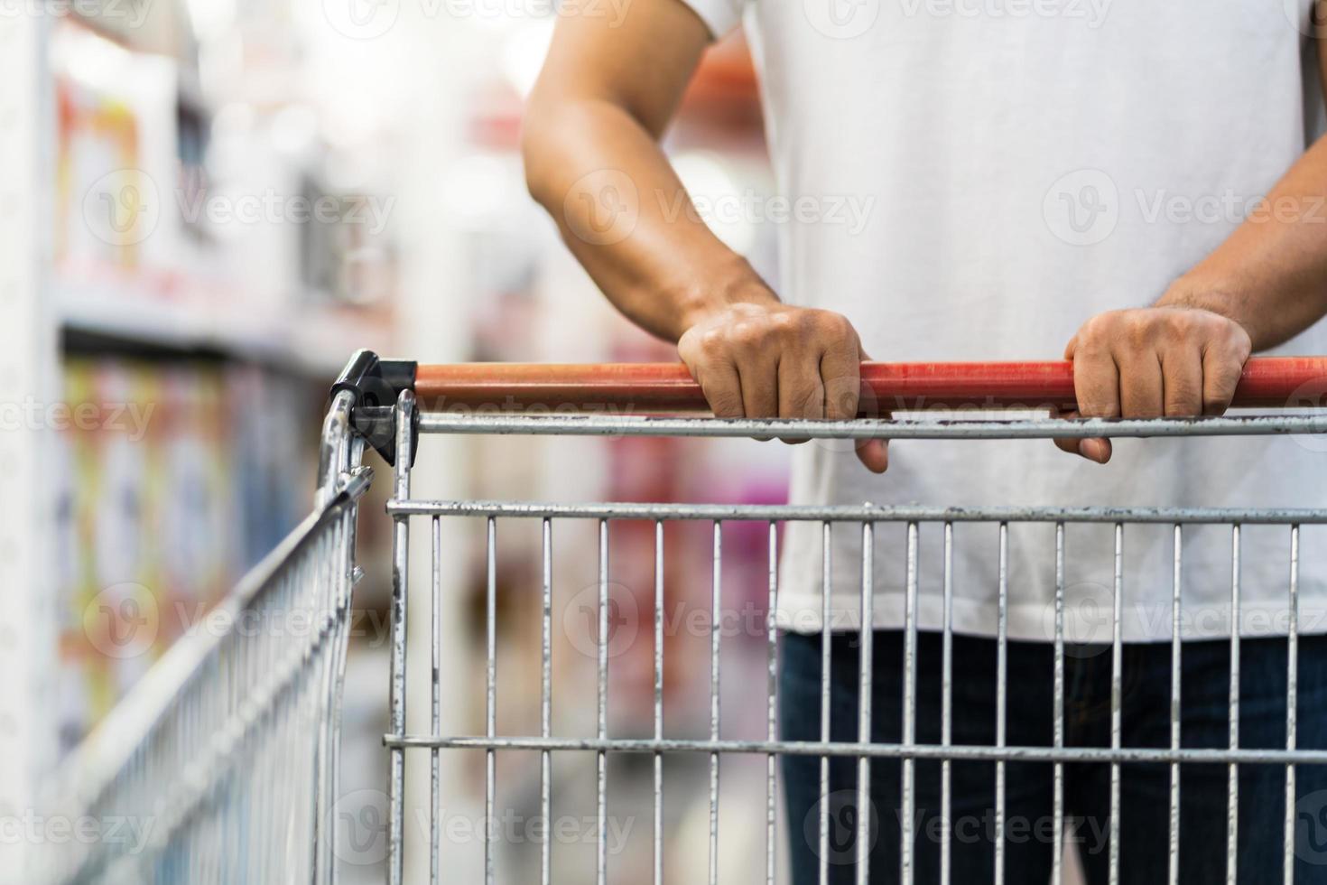 close-up van man duwen winkelwagentje in een supermarkt a foto