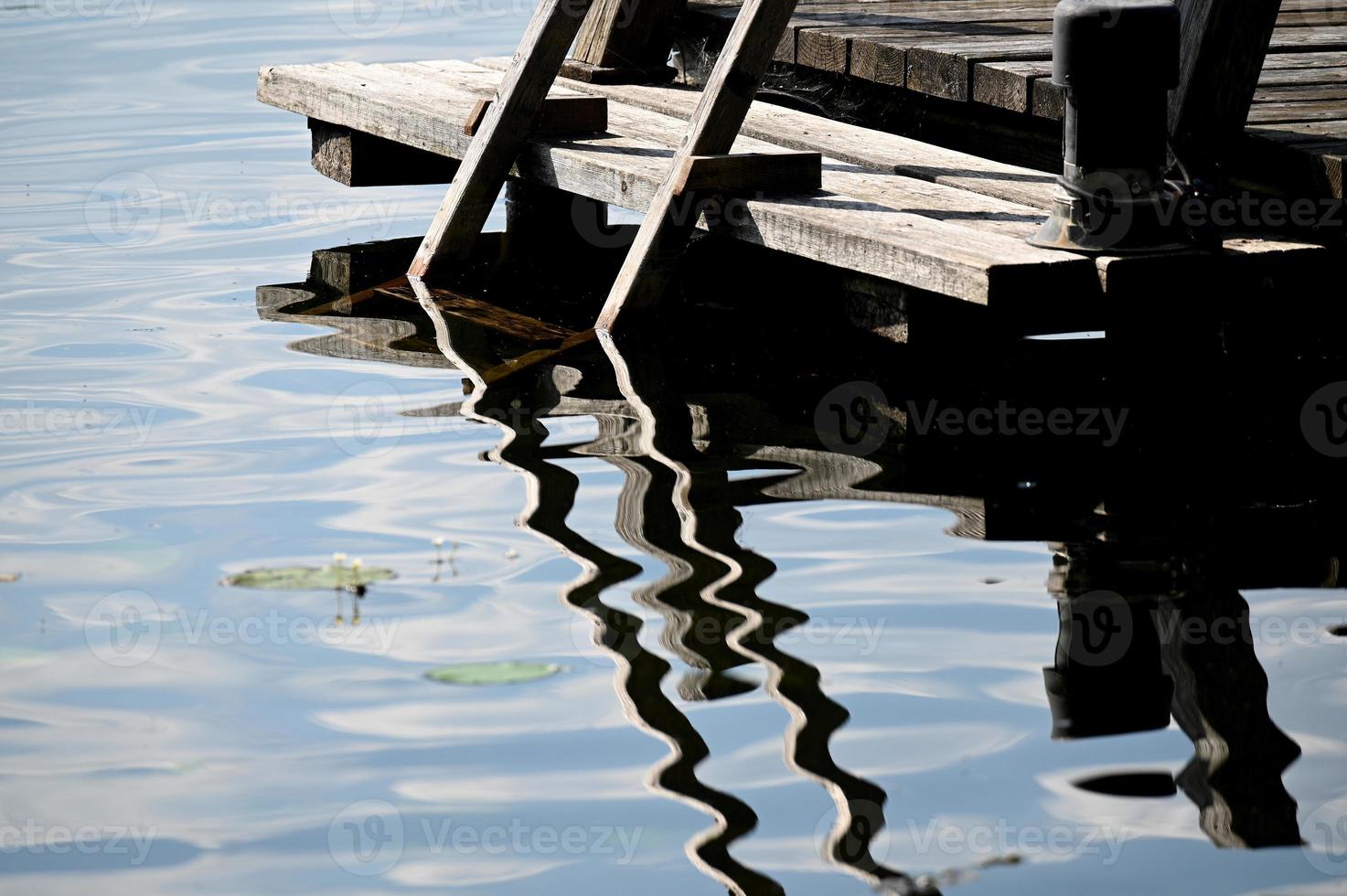 een houten trede en zijn weerspiegeling in het water foto