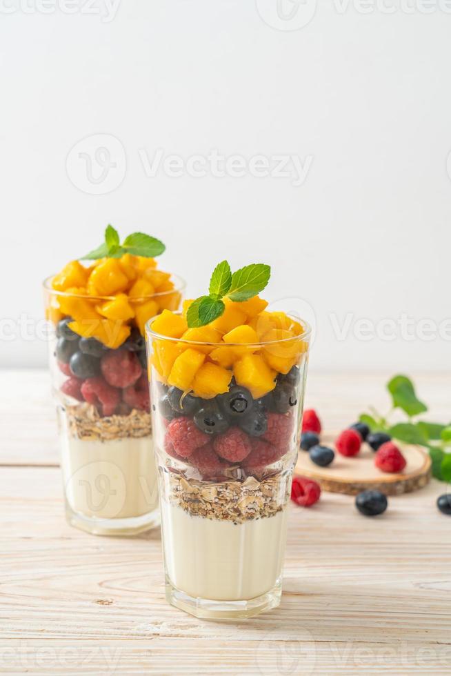 zelfgemaakte mango, framboos en bosbes met yoghurt en muesli - gezonde voedingsstijl foto