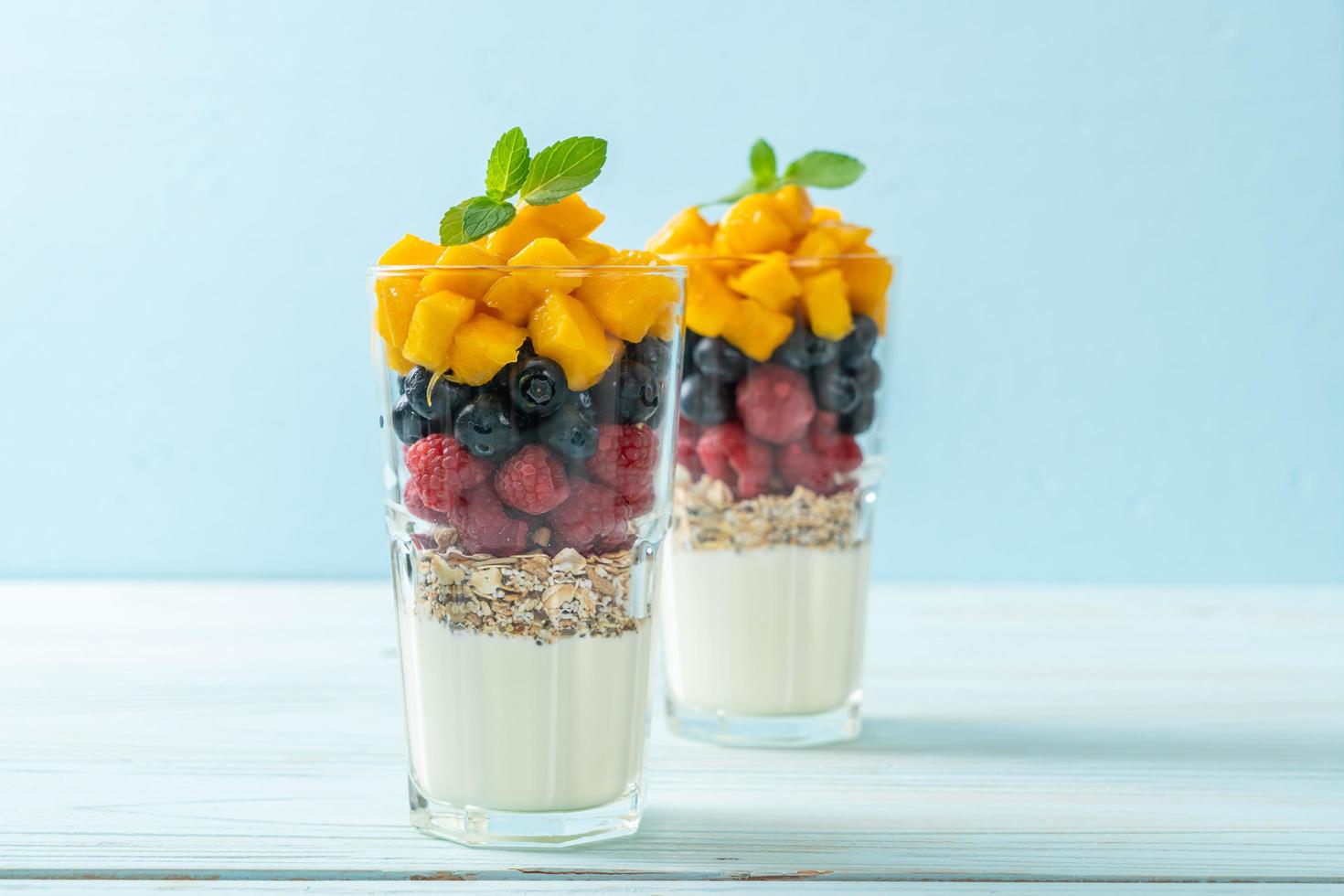 zelfgemaakte mango, framboos en bosbes met yoghurt en muesli - gezonde voedingsstijl foto