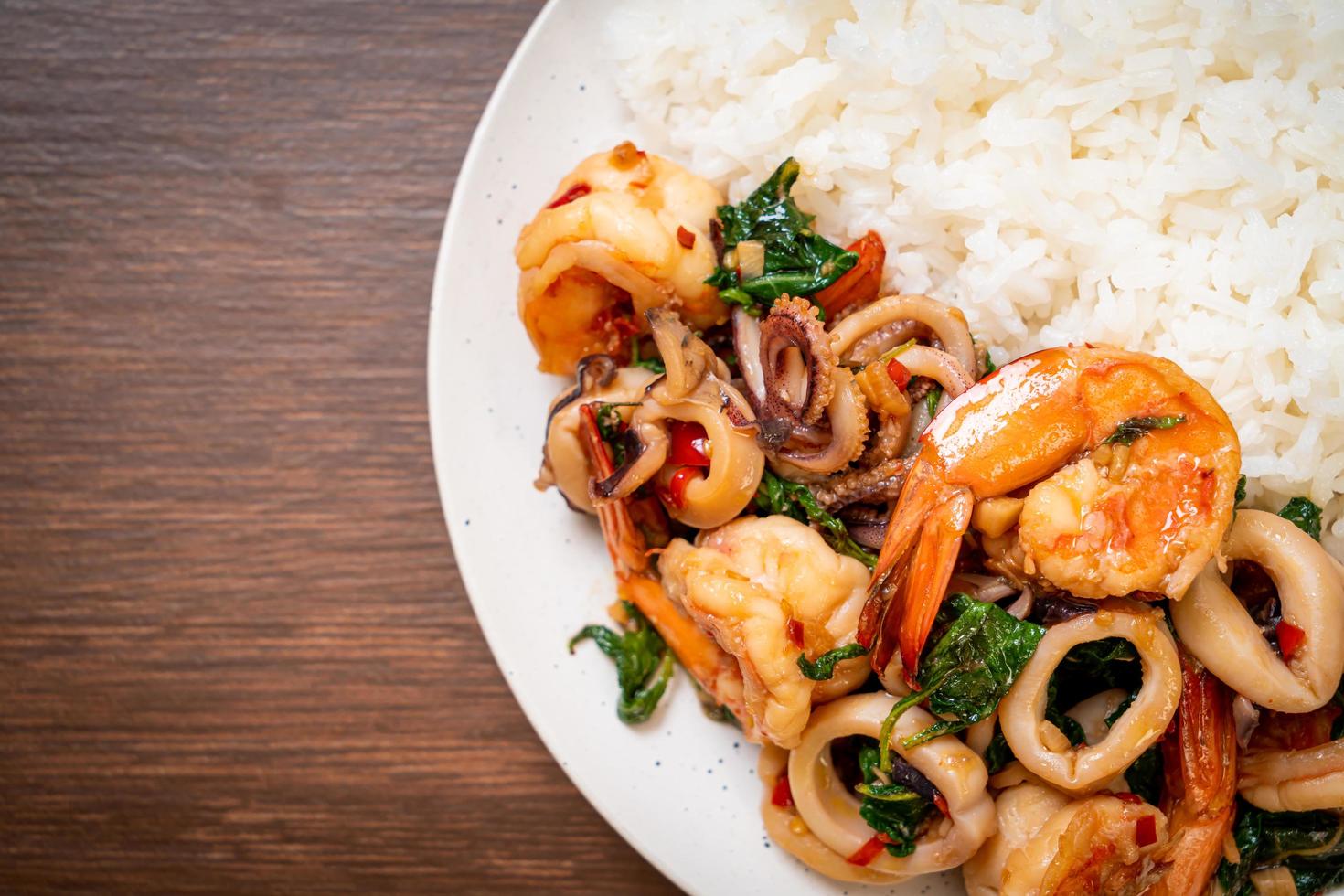 rijst en roergebakken zeevruchten van garnalen en inktvis met thaise basilicum - Aziatisch eten foto