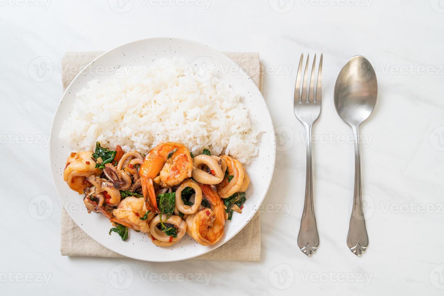 rijst en roergebakken zeevruchten van garnalen en inktvis met thaise basilicum - Aziatisch eten foto