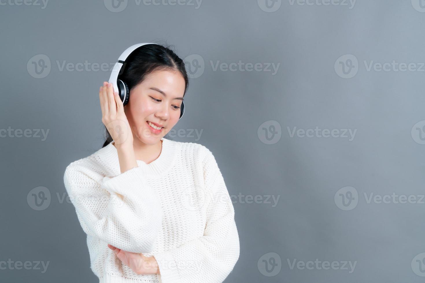 jonge aziatische vrouw die naar muziek luistert met een koptelefoon foto