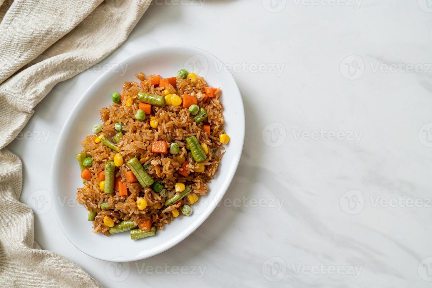 gebakken rijst met groene erwten, wortelen en maïs - vegetarische en gezonde voedingsstijl foto