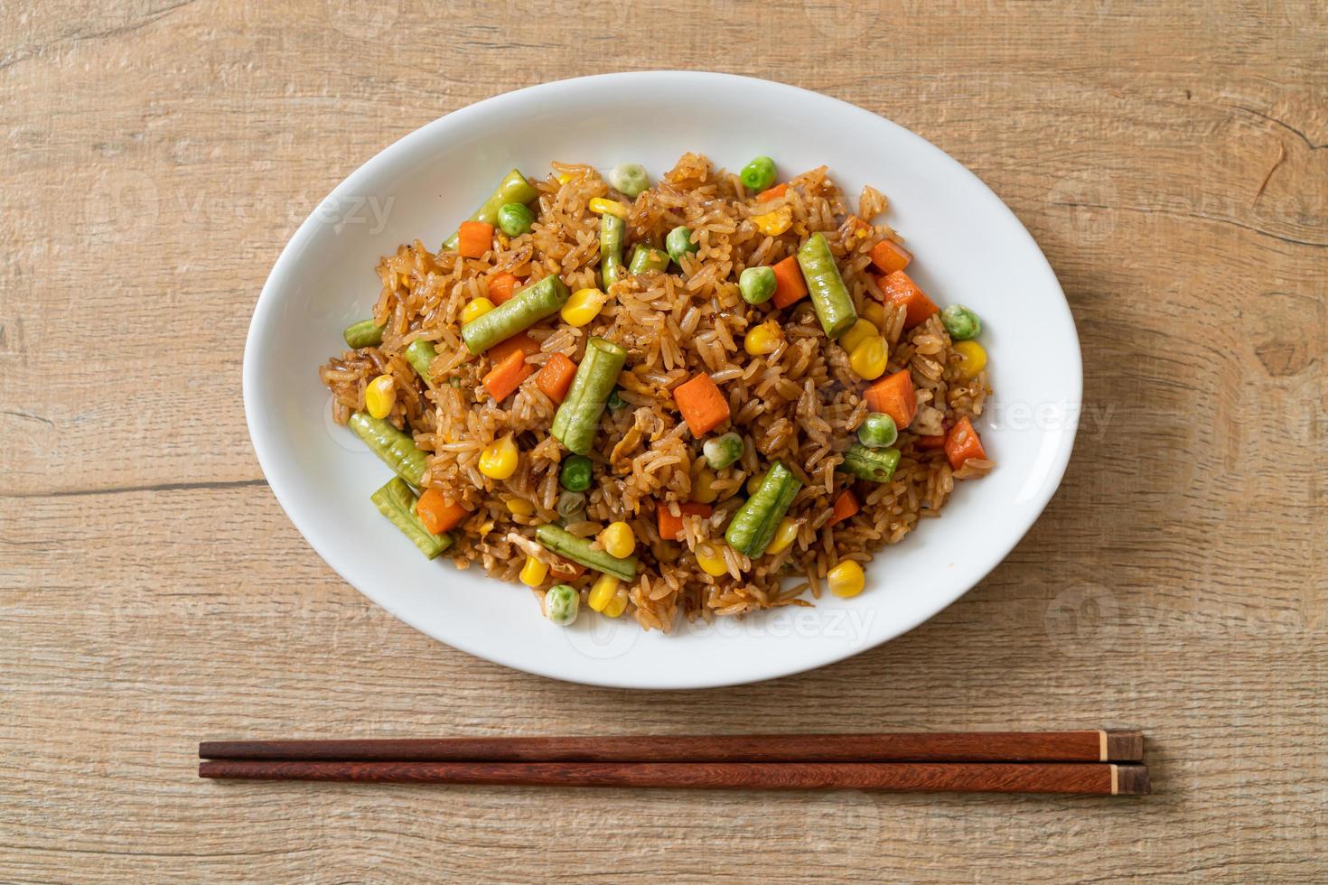 gebakken rijst met groene erwten, wortelen en maïs - vegetarische en gezonde voedingsstijl foto