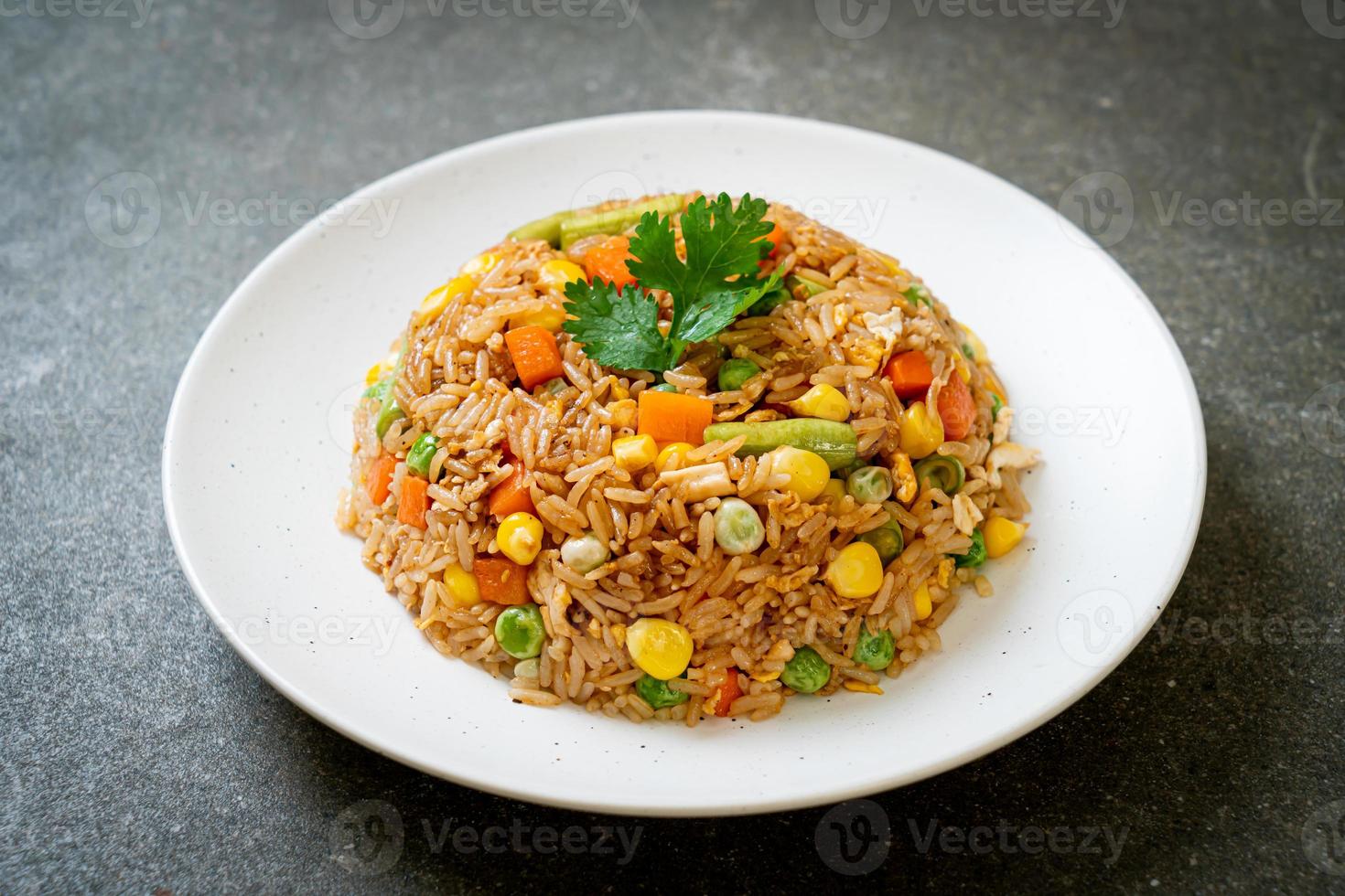 gebakken rijst met groene erwten, wortelen en maïs - vegetarische en gezonde voedingsstijl foto