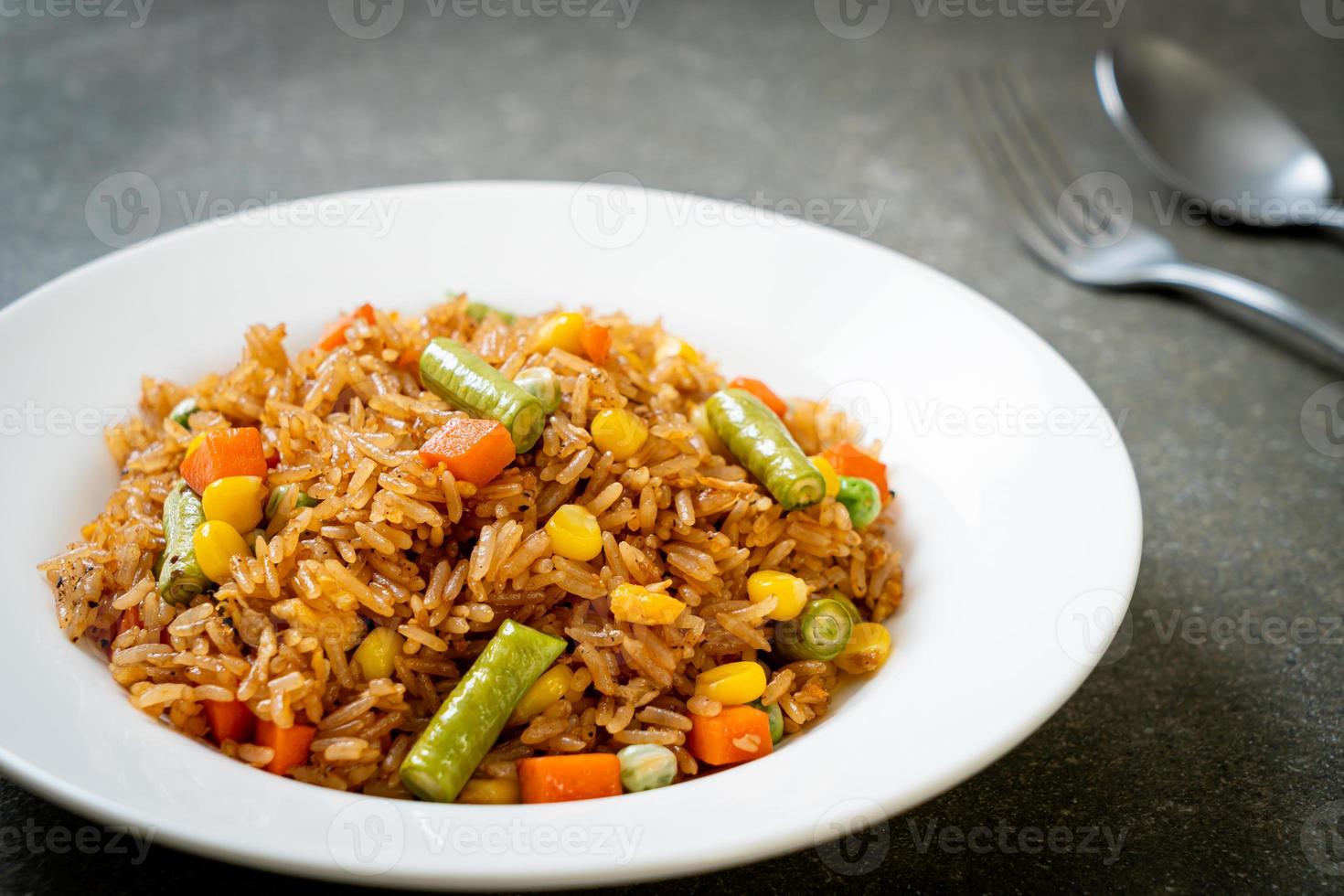 gebakken rijst met groene erwten, wortelen en maïs - vegetarische en gezonde voedingsstijl foto