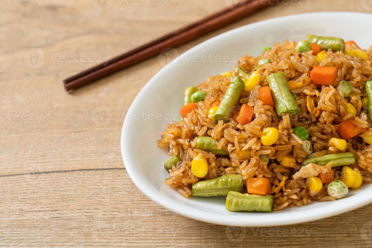 gebakken rijst met groene erwten, wortelen en maïs - vegetarische en gezonde voedingsstijl foto