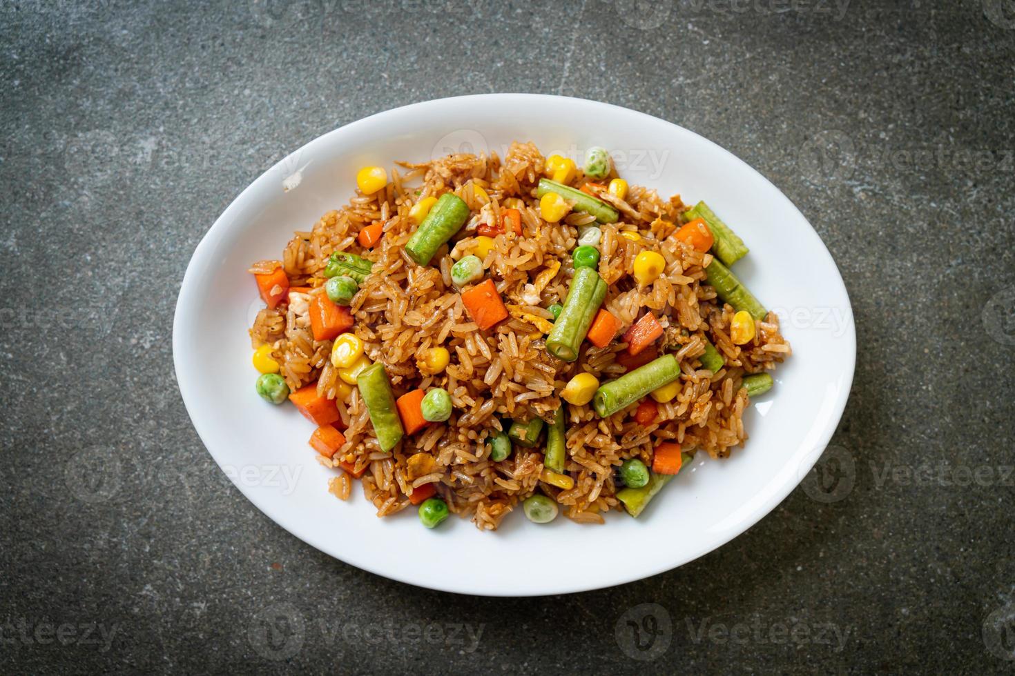 gebakken rijst met groene erwten, wortelen en maïs - vegetarische en gezonde voedingsstijl foto