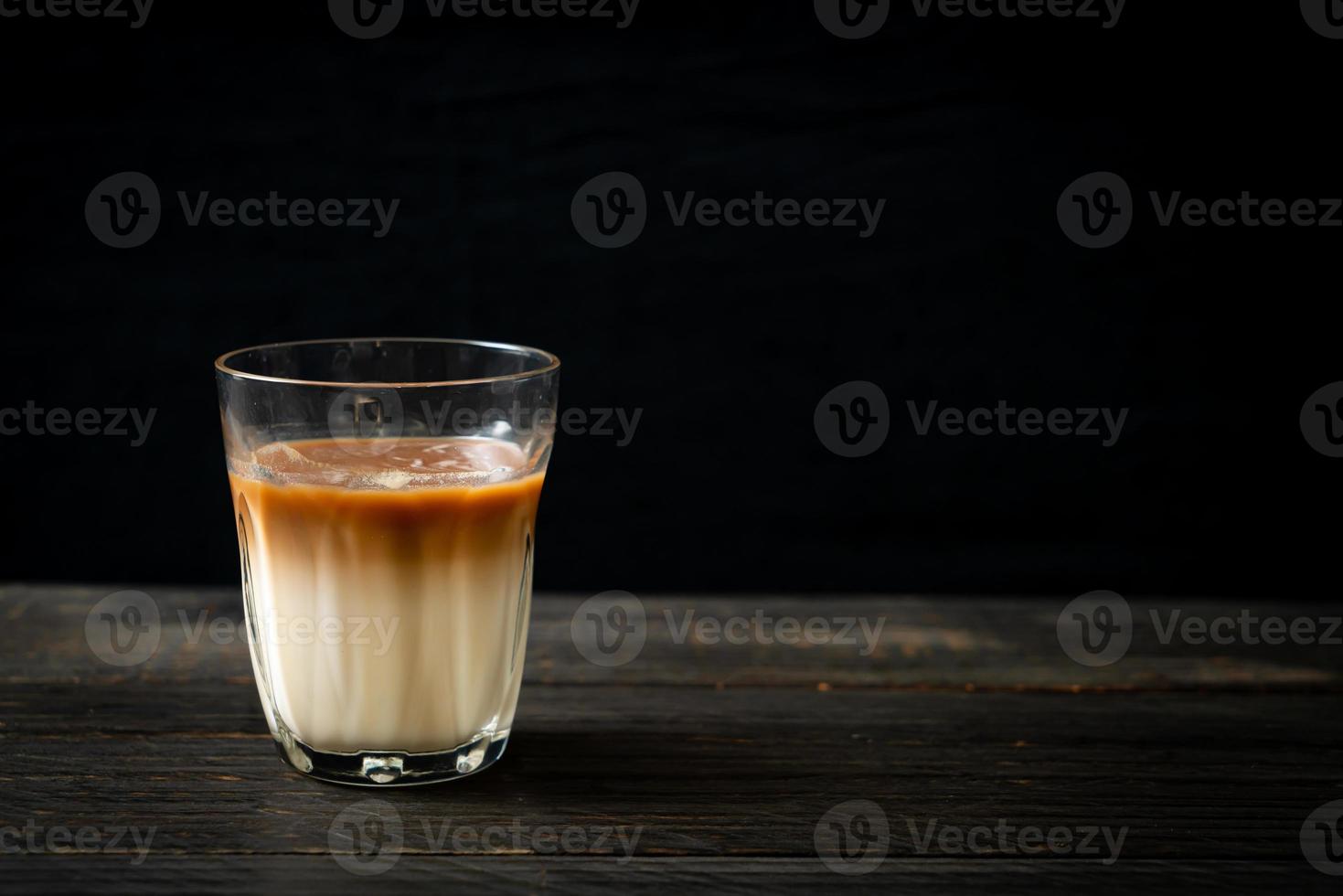 glas latte koffie, koffie met melk op hout achtergrond foto